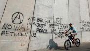 Ein arabischer Junge fährt im Osten Jerusalems auf einem Rad am Trennwall zwischen Israel und dem palästinensischen Gebiet entlang. (picture alliance / dpa / Oliver Weiken)